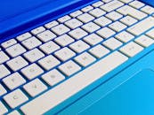 白色电脑键盘在蓝色笔记本电脑上的详细特写图像