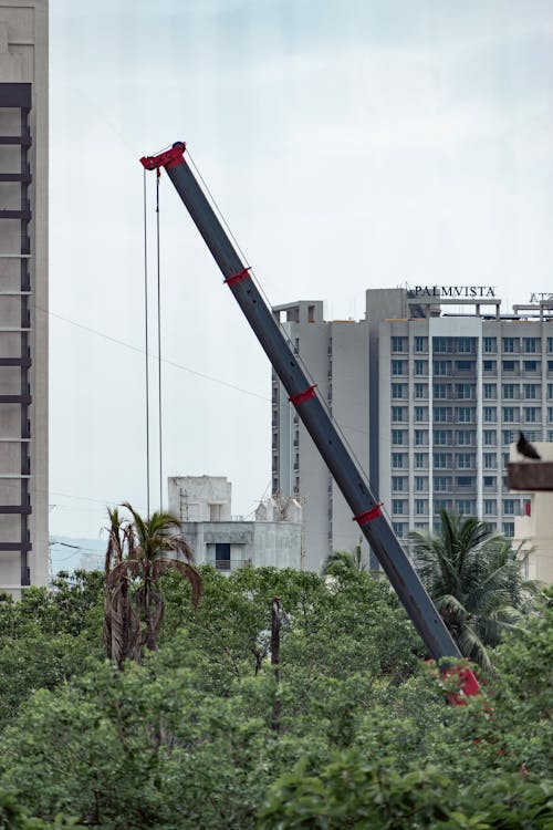 A crane is lifting a large object over a city