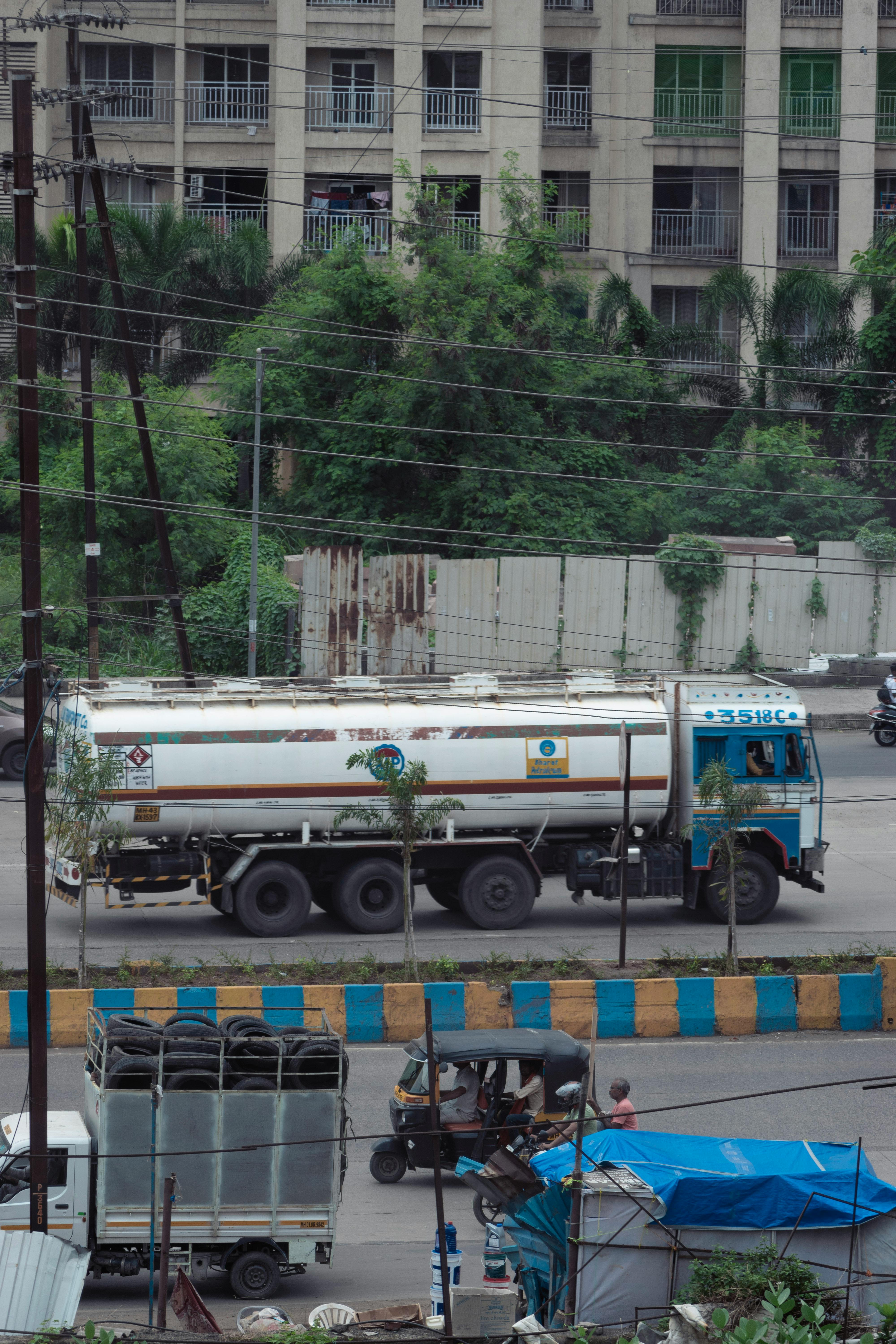 Free A bustling city street with a tanker truck and power lines, surrounded by urban buildings. Stock Photo