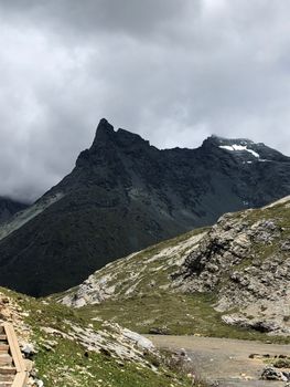 A scenic view of a rugged mountain peak shrouded in clouds, highlighting its rocky terrain.
