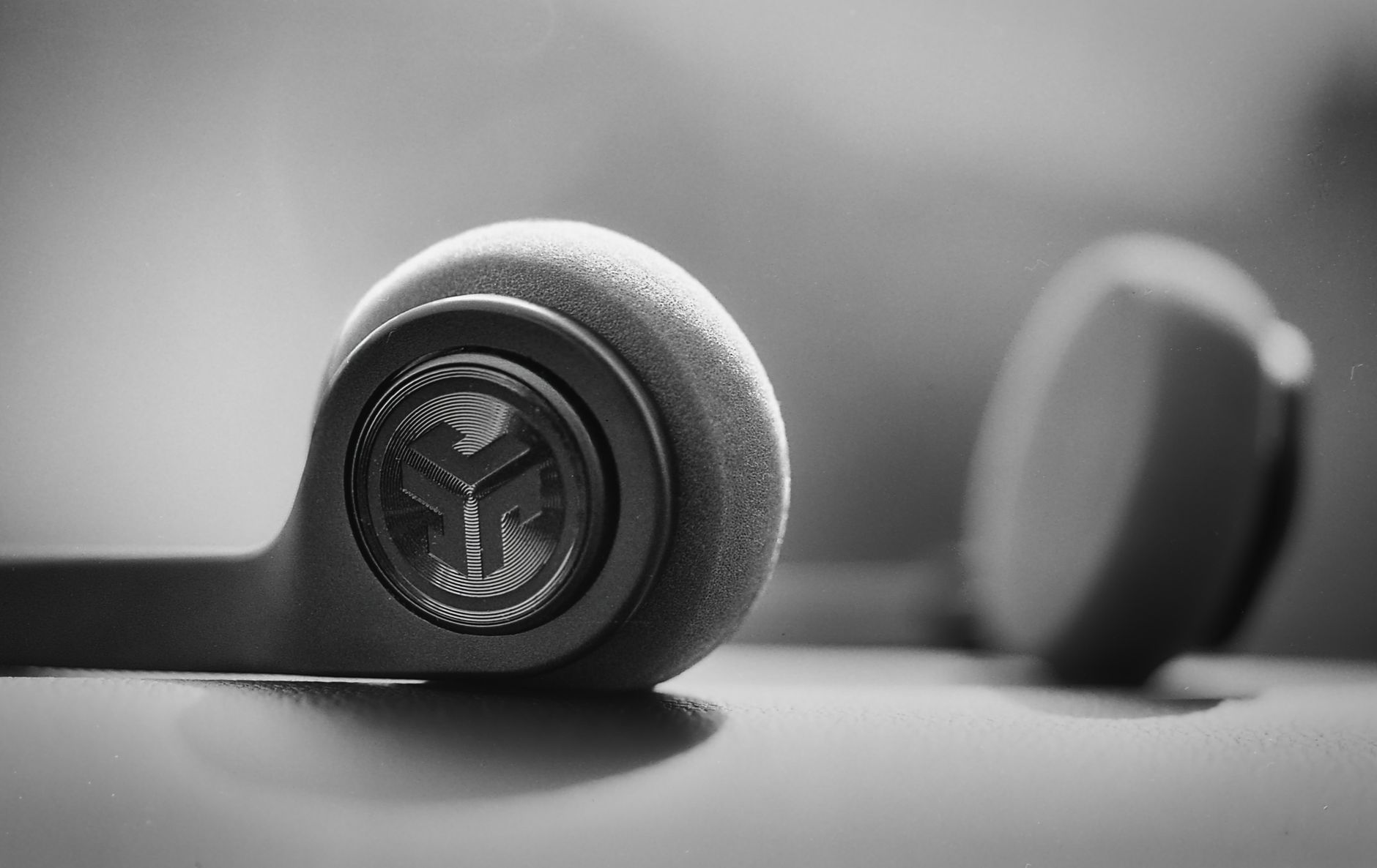 Artistic black and white close-up of wireless headphones, highlighting modern design.