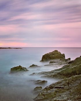 岩石海岸上，日落景色迷人，天空柔和