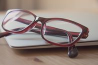 Eyeglasses With Red Frames on Laptop Computer