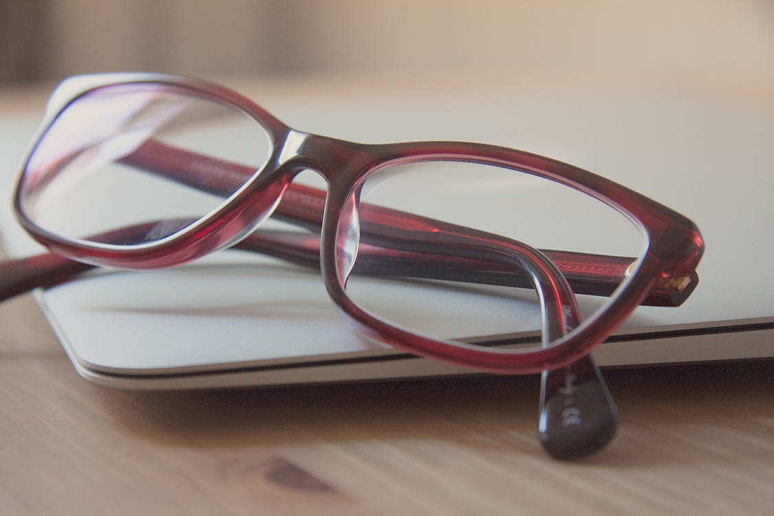 Free Eyeglasses With Red Frames on Laptop Computer Stock Photo