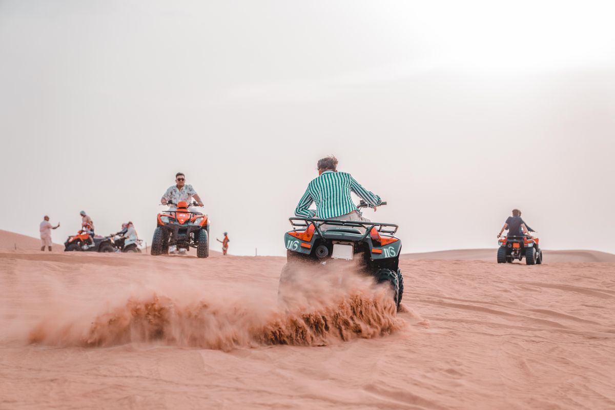 ATV riders crossing scenic desert dunes