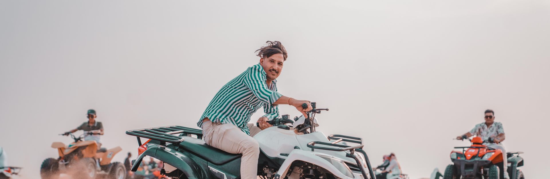 Group riding quads in a vast desert landscape, exuding adventure and excitement.