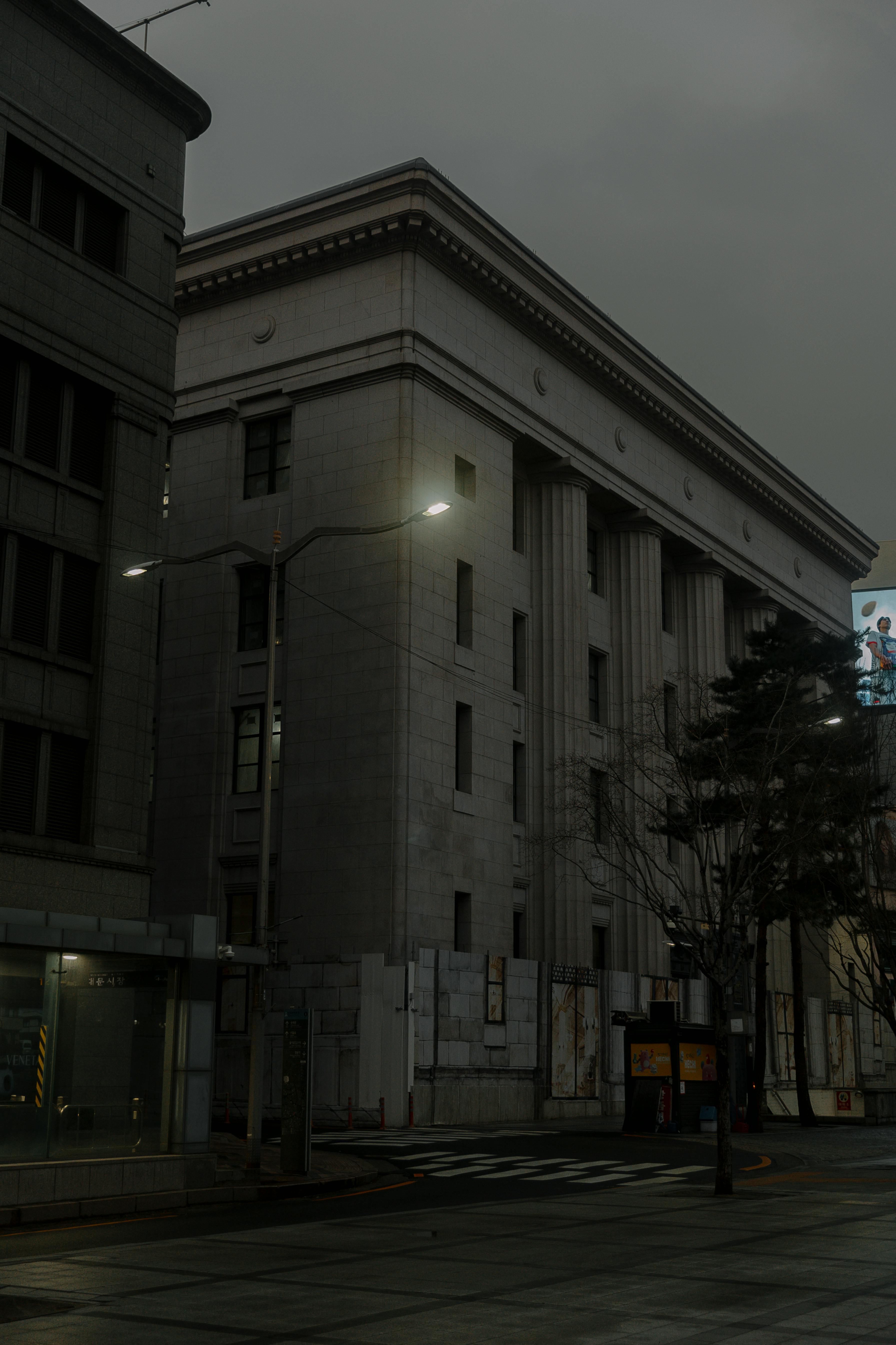 Free A dark, moody urban scene showcasing classic architecture under cloudy skies. Stock Photo