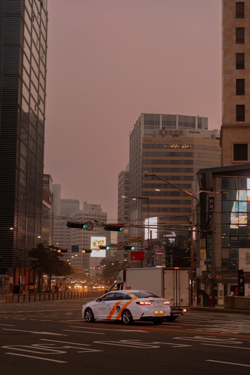 A car driving down a city street at dusk