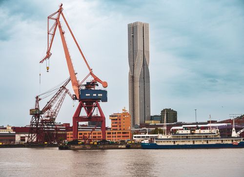 Free View of Göteborg harbor featuring Karlatornet skyscraper and industrial cranes by the river. Stock Photo