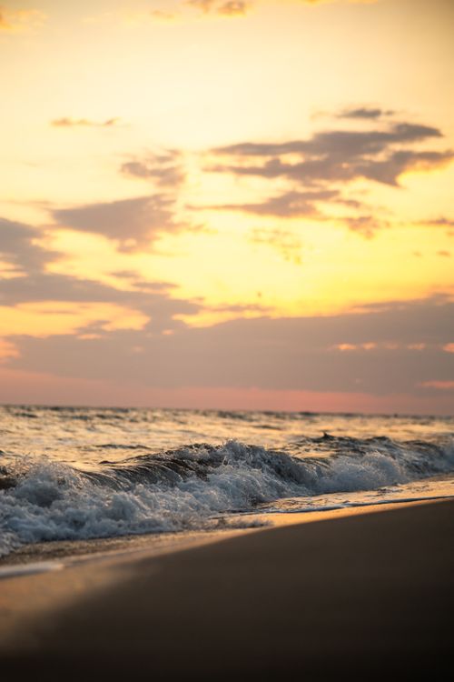 Free Peaceful ocean scene with waves and a dramatic sky at sunset, highlighting the beauty of nature. Stock Photo