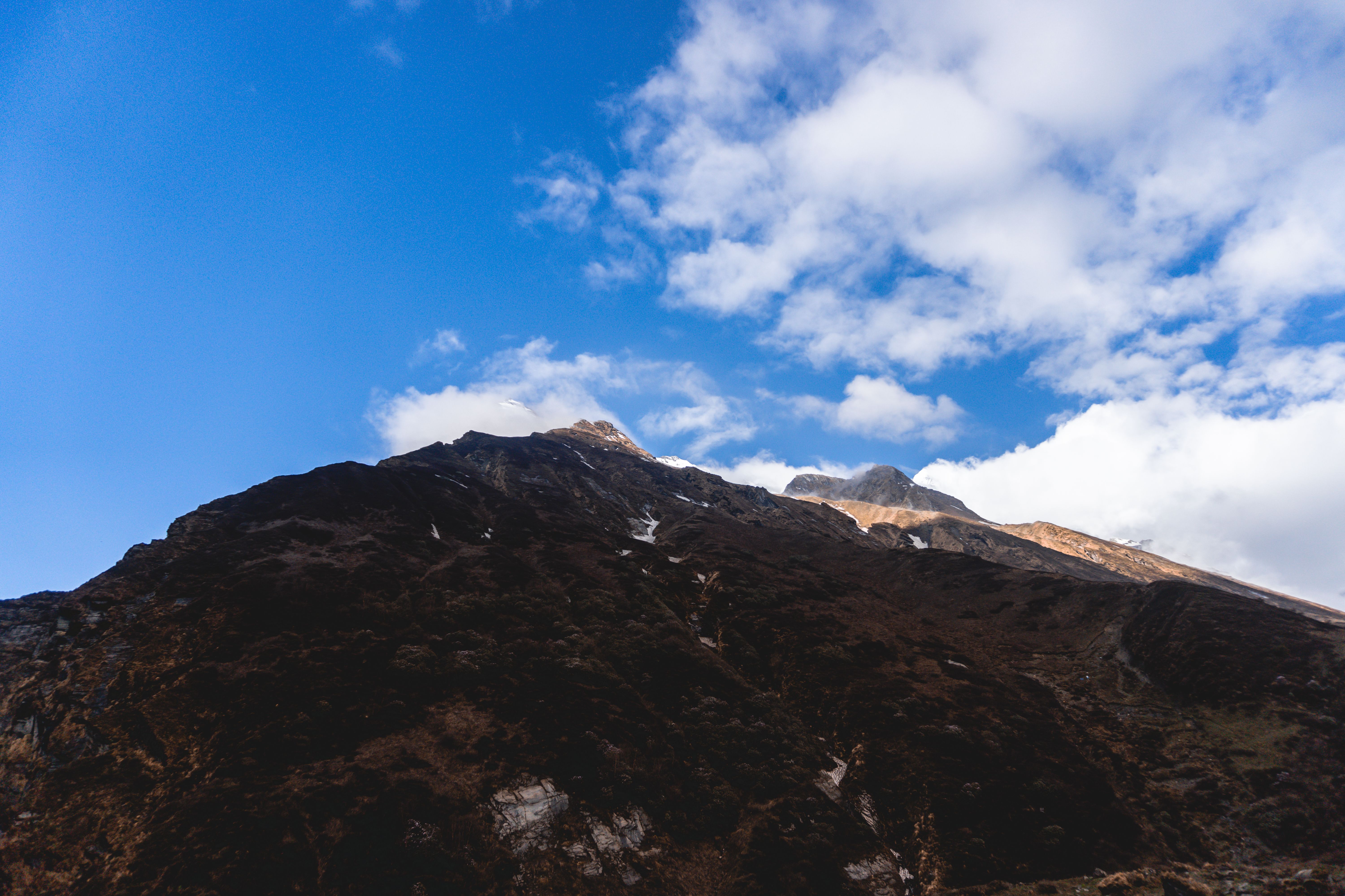 Breathtaking image of the Machhapuchchhre mountain peak, showcasing natural beauty with a blue sky backdrop.