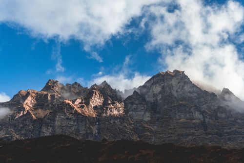 Free Dramatic clouds hover over the rugged peaks of Machhapuchchhre in Nepal, showcasing natural splendor. Stock Photo