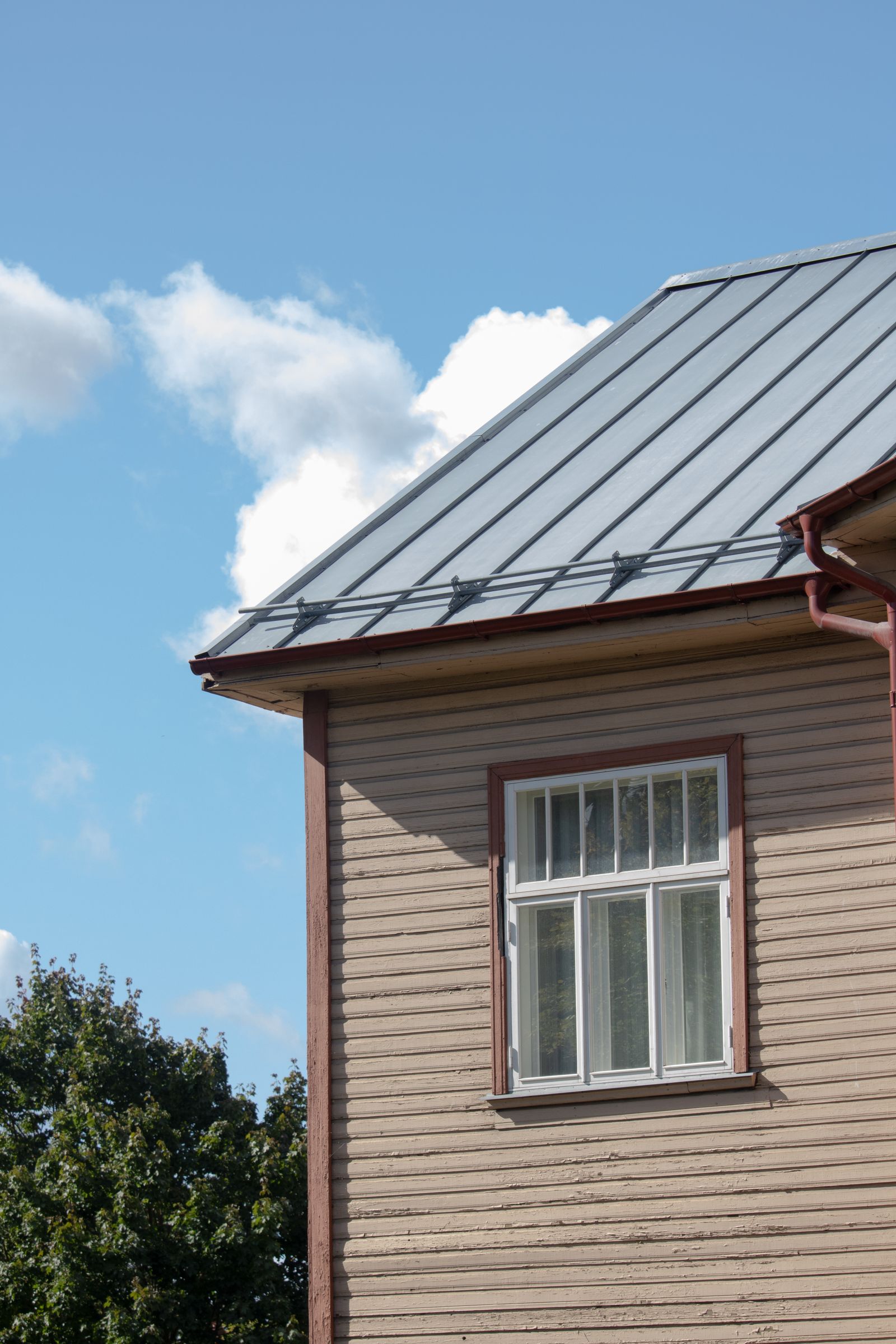 Standing-seam metal roof on a timber-clad house