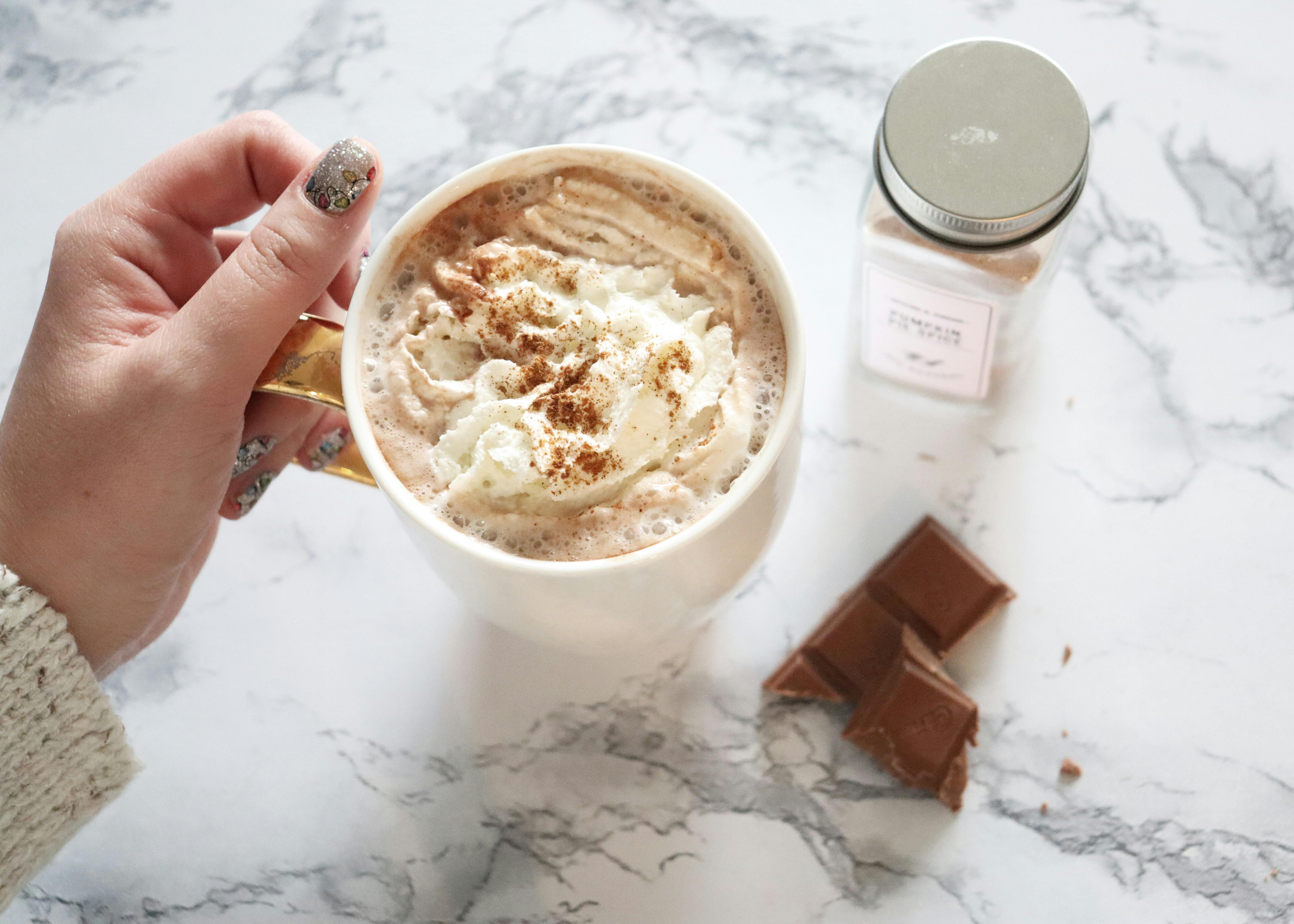 Enjoy a cozy cup of hot chocolate with whipped cream and chocolate sprinkles for a delightful treat.