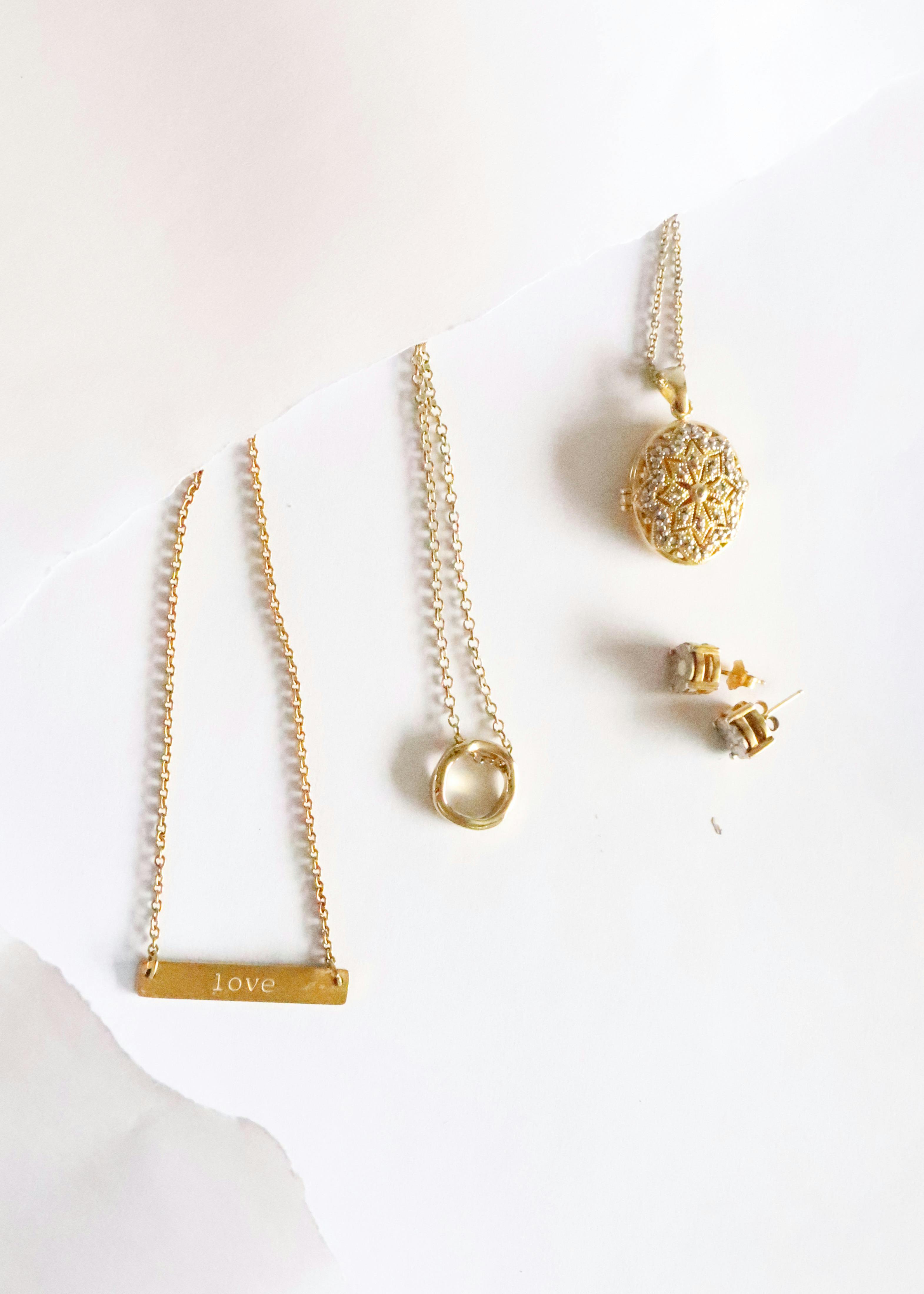 gold jewellery on white surface