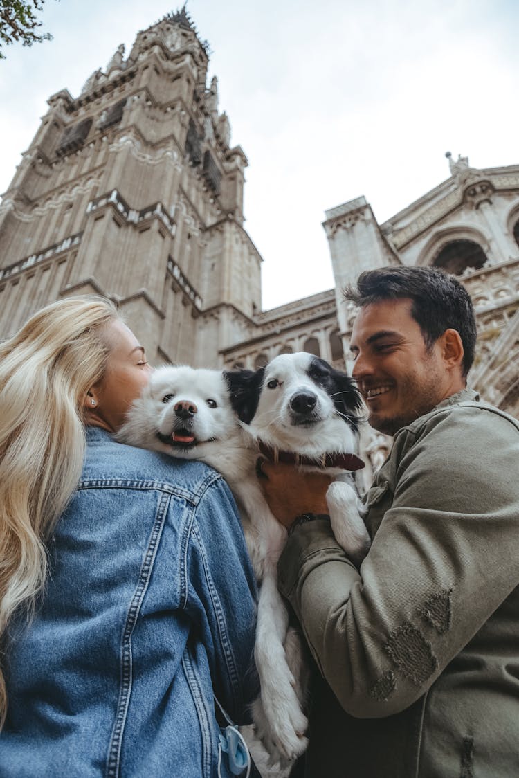 Couple Hugging Their Dogs