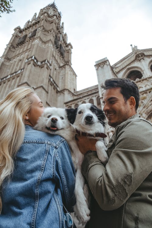 Free Couple holding two dogs in front of cathedral Stock Photo