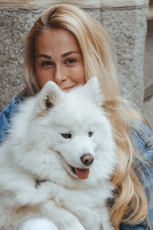 A woman with blonde hair and a white dog