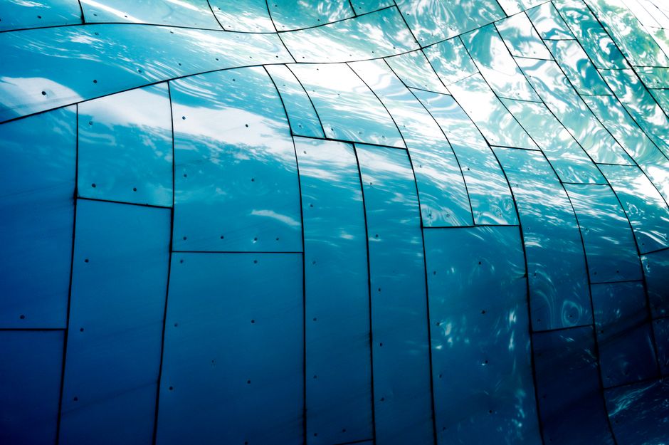 Abstract view of reflective blue metal panels in Seattle, capturing light and texture.