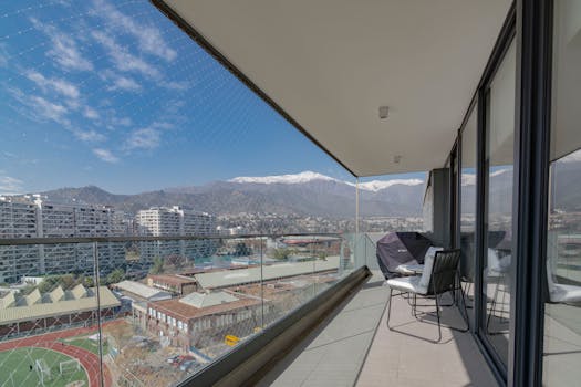 Enjoy a stunning cityscape from a contemporary balcony with mountain views.