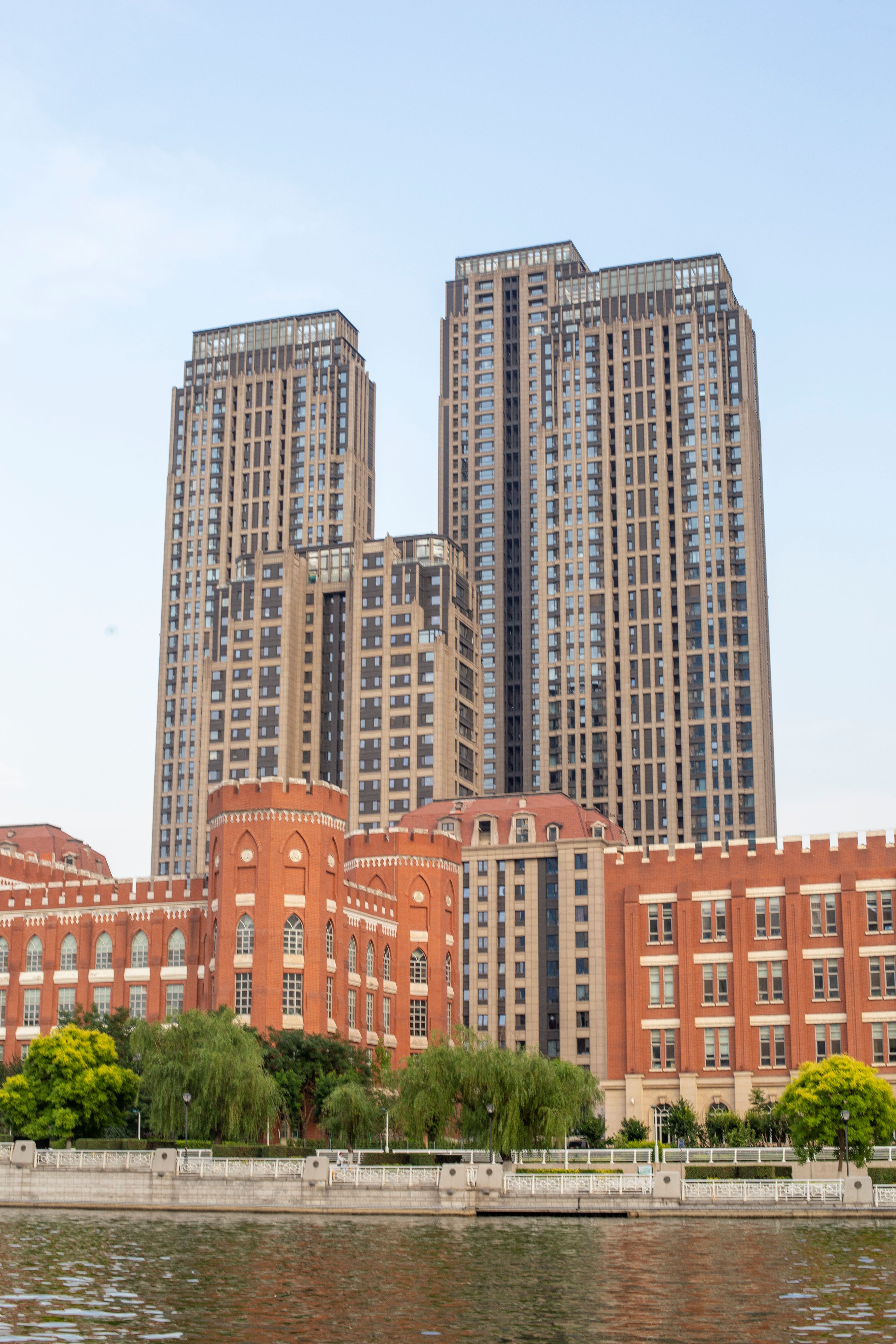 A large building with tall buildings in front of a river · Free Stock Photo