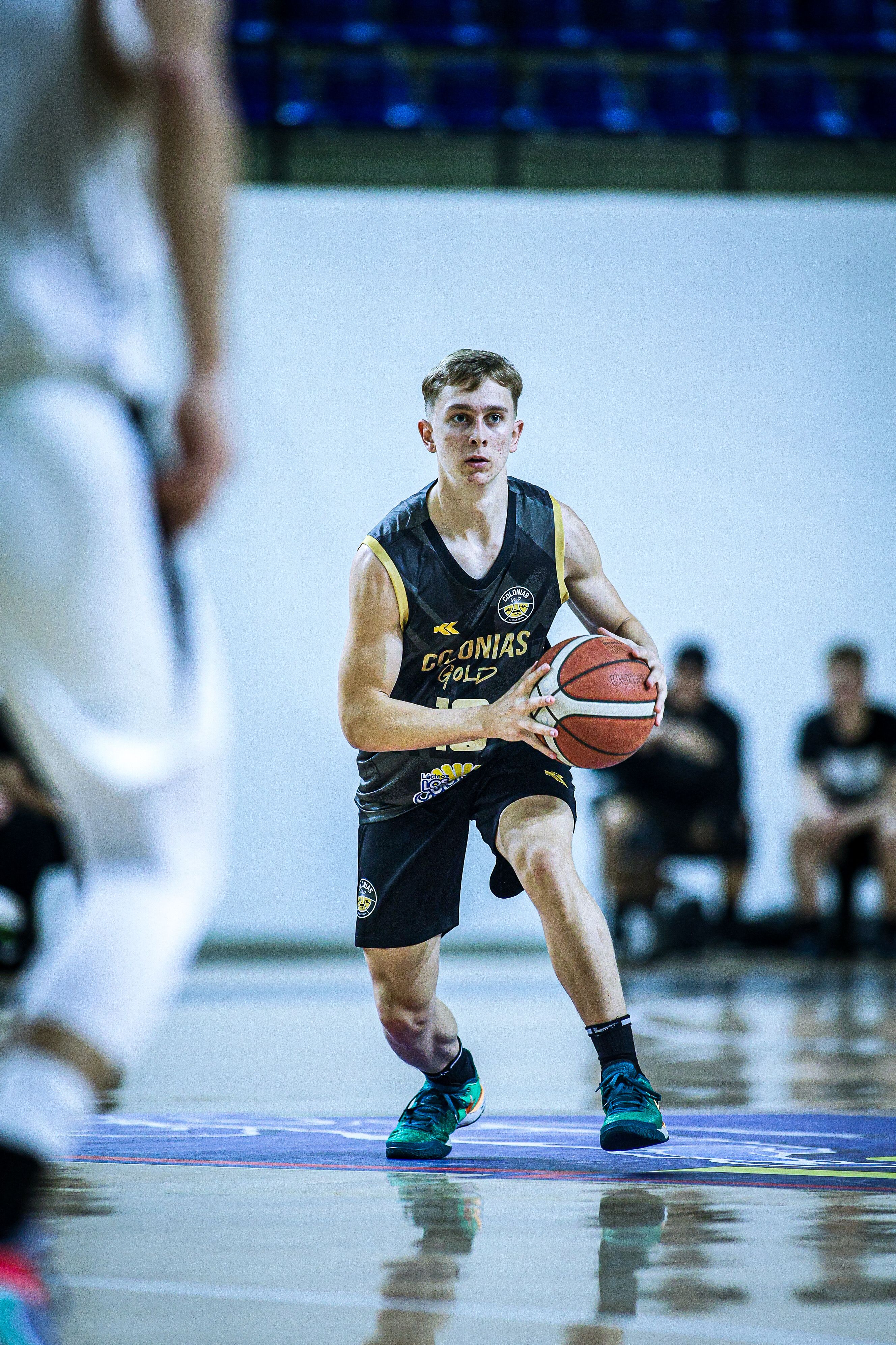 Focused young athlete playing basketball indoors in Paraguay.