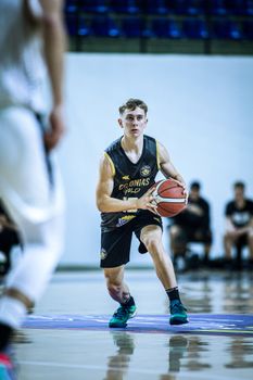 Focused young athlete playing basketball indoors in Paraguay.