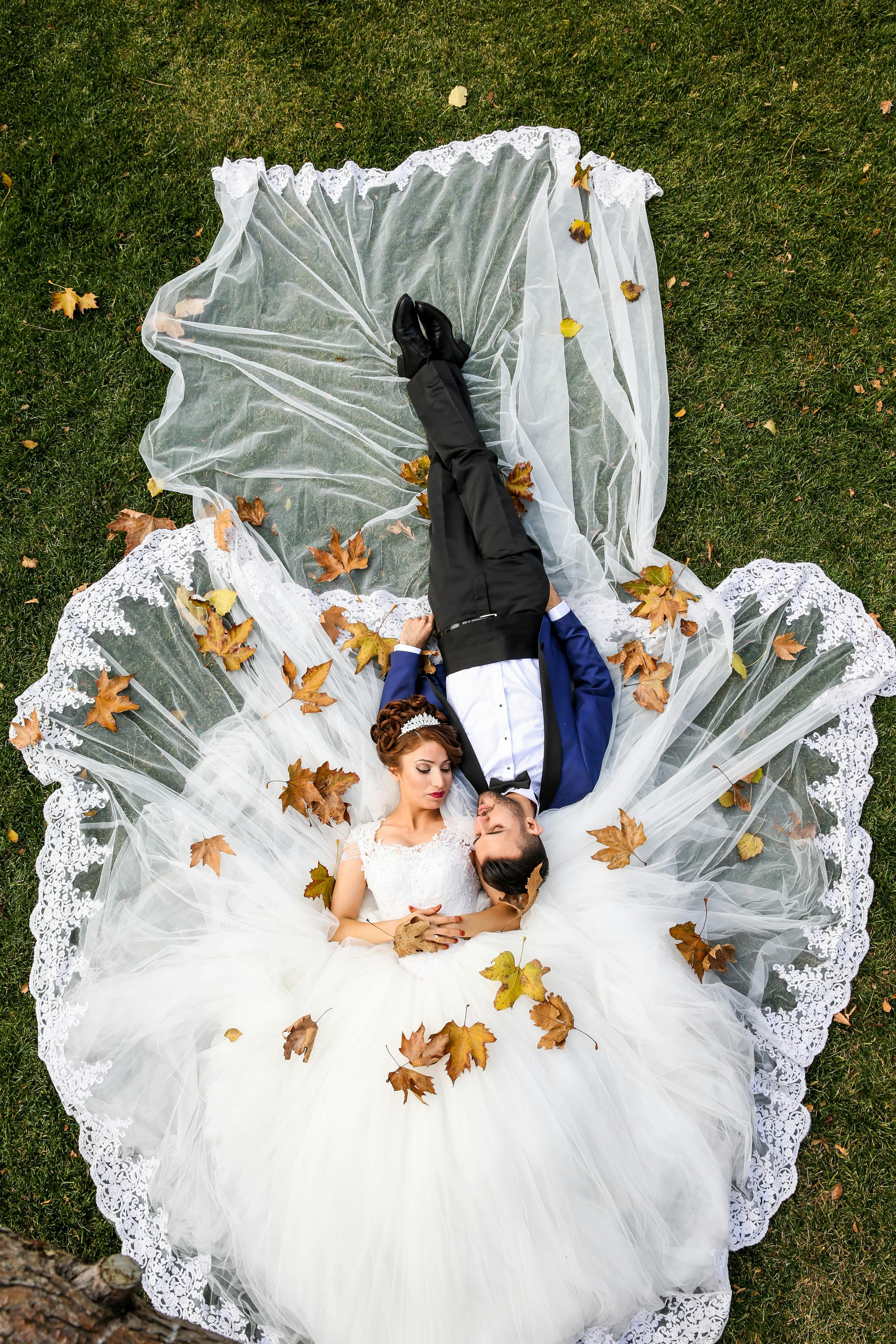 Man and woman lying on grass field. | Photo: Pexels