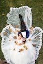 Aerial Photo of Man and Woman Lying on Grass Field