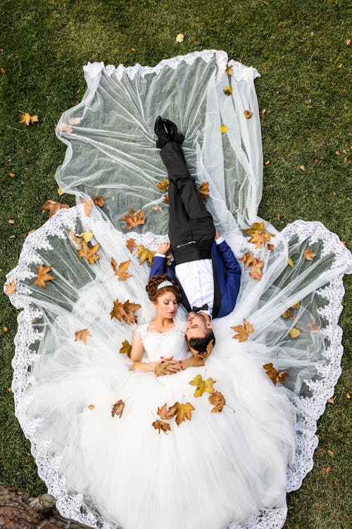 бесплатная Аэрофотоснимок мужчины и женщины, лежащих на траве Стоковое фото