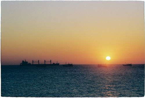 Free Captivating sunset over Vũng Tàu harbor with ships silhouetted against the ocean horizon. Stock Photo