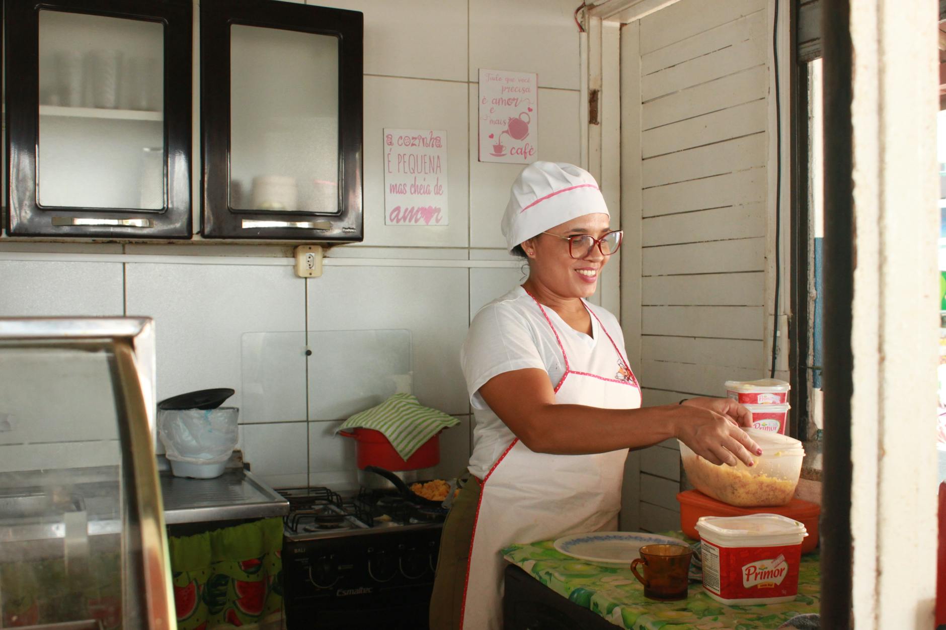 A woman in a white apron is making food