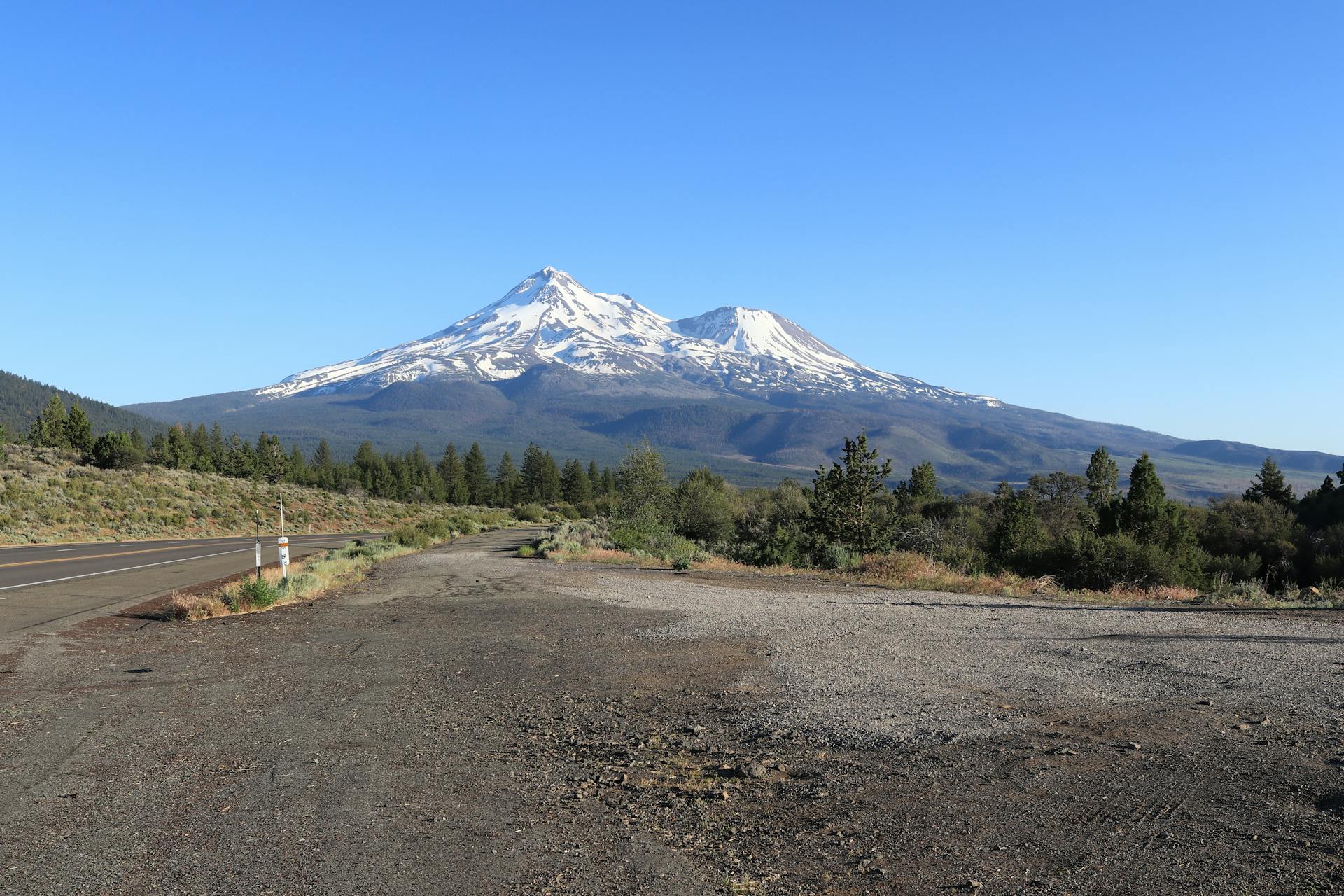 Majestic Mount Shasta with snowcapped peaks against a clear blue sky in northern California.