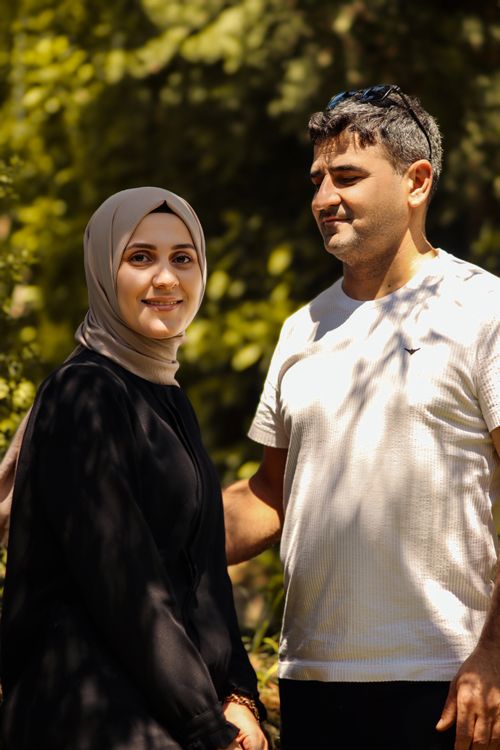 Free Happy couple enjoying a sunny day outdoor in a lush garden setting. Stock Photo