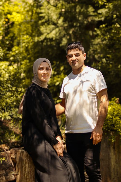 Free A joyful couple enjoying a sunny day in a lush green park, surrounded by nature. Stock Photo