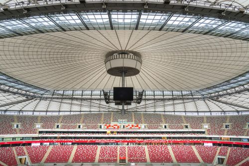 Free View of Warsaw's National Stadium showcasing its iconic roof design and vibrant seating. Stock Photo