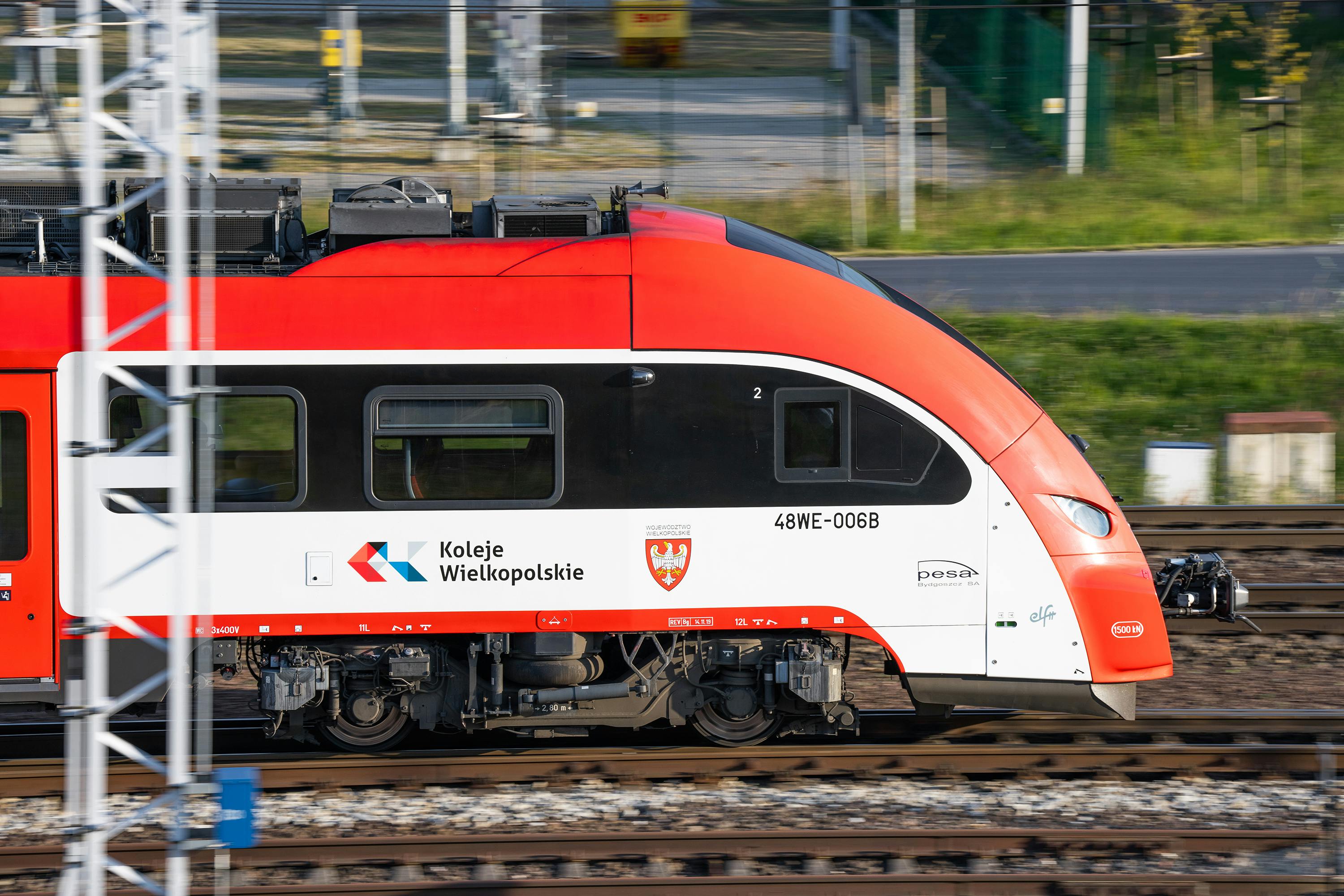 Free Side view of a Koleje Wielkopolskie train speeding on tracks in Poznań, Poland. Stock Photo