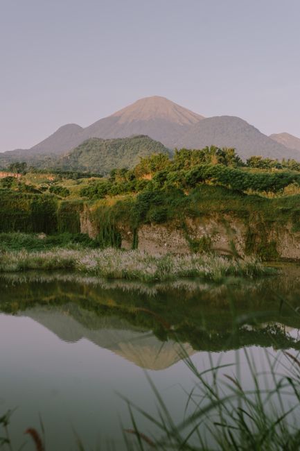Peaceful mountain scene with serene water reflection at sunrise.