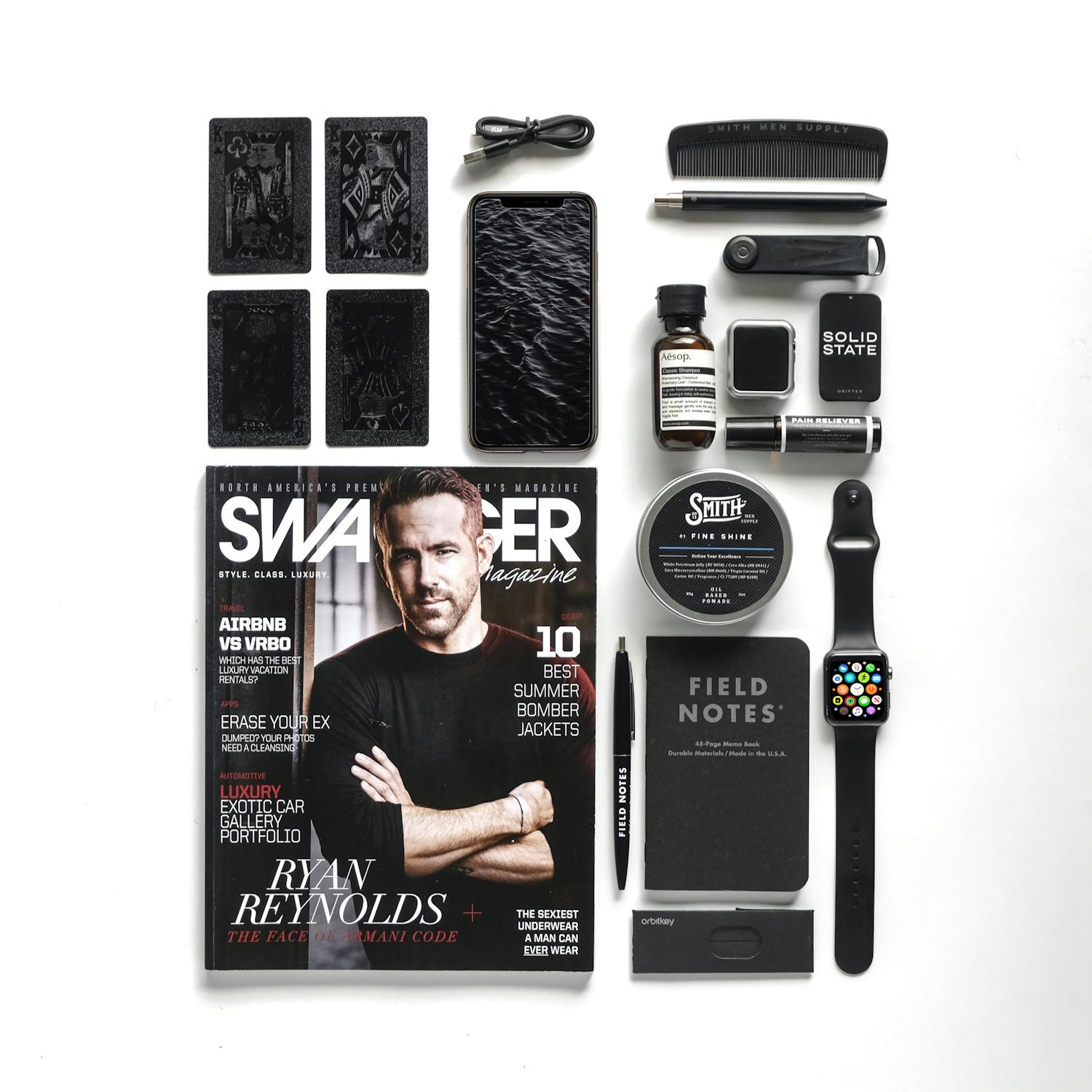 Modern flat lay featuring tech gadgets, Swagger magazine, and Field Notes, perfect for contemporary lifestyle enthusiasts.