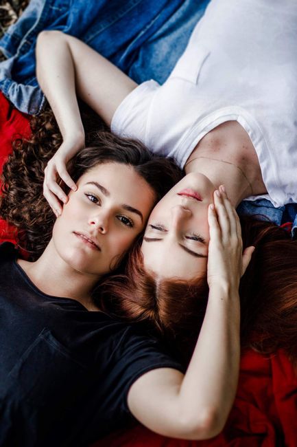 A serene and intimate portrait of two women lying together, showcasing love and connection.