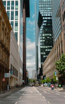 Urban scene of a busy street in Frankfurt with towering skyscrapers and vehicles.