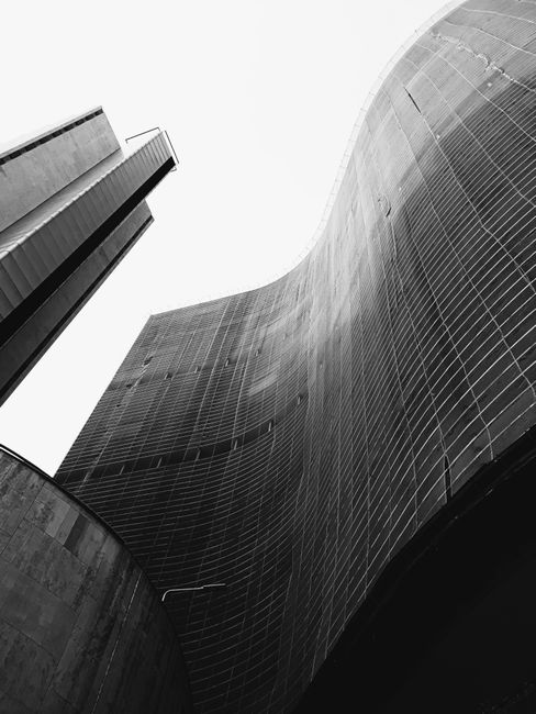 Unique perspective of a modern skyscraper with curved lines in black and white.