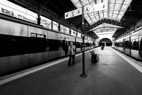 Free Dramatic black and white photo of a man walking at the São Bento train station in Porto, Portugal. Stock Photo