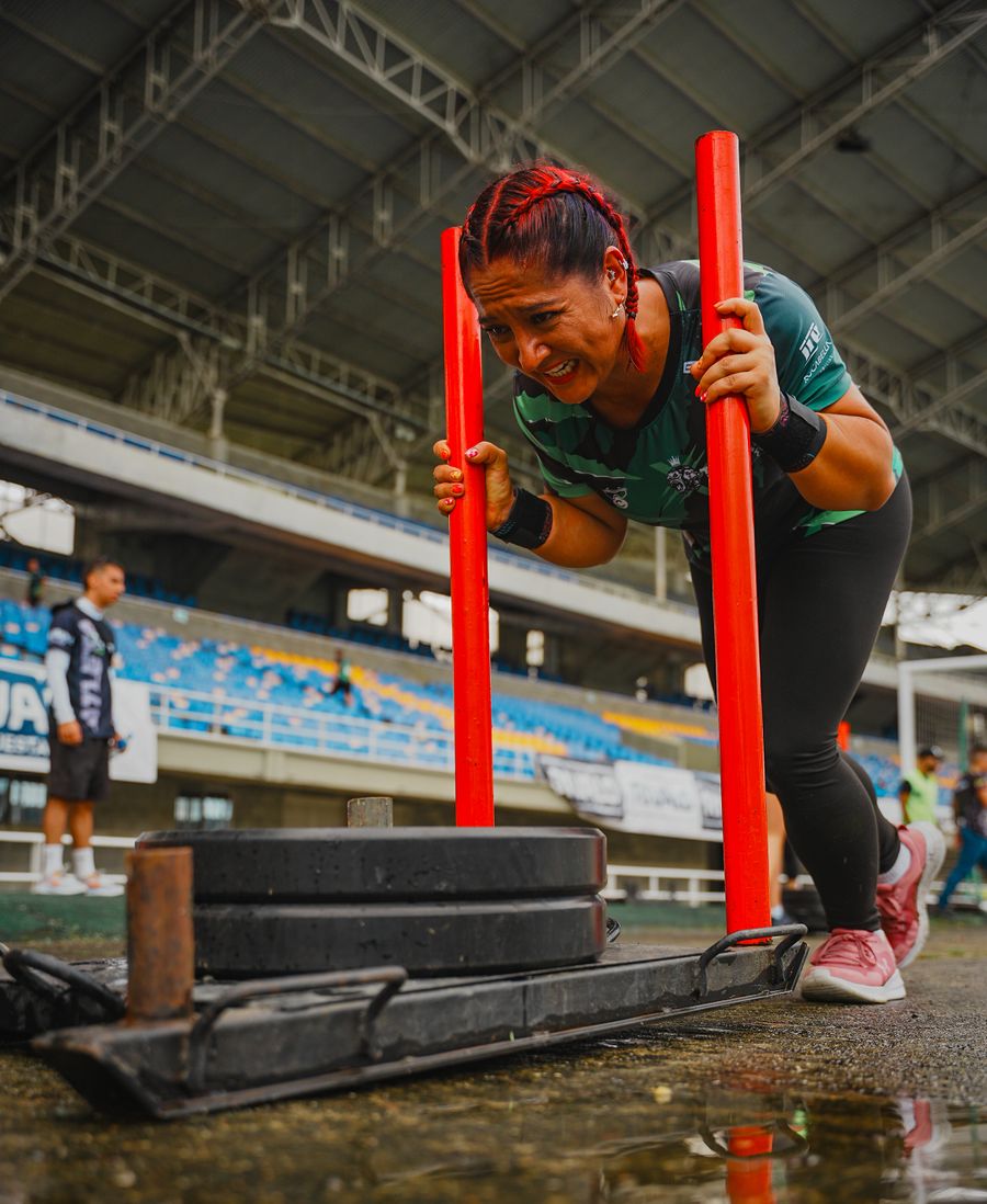 Woman pushing a heavy sled at an outdoor race