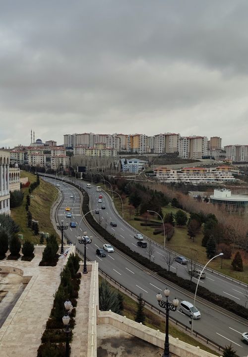 Free Aerial view of a cityscape with apartment buildings and a busy road on an overcast day. Stock Photo