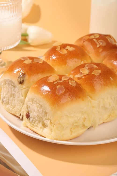 Free Close-up of golden brown sweet rolls with almonds on a plate, perfect for breakfast or dessert. Stock Photo