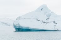 一座孤独的冰山漂浮在冰岛冰冷的海水中，展现了大自然的冰冷之美