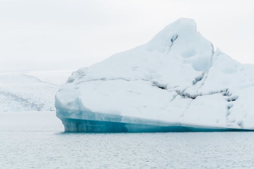一座孤独的冰山漂浮在冰岛冰冷的海水中，展现了大自然的冰冷之美