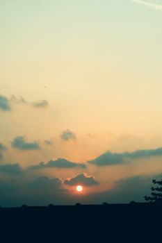 Serene sunset scene with silhouettes of rooftops under a colorful sky in Bekasi, Indonesia.