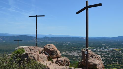 Free Crosses atop a rocky hill in Roquebrune-sur-Argens, France, offer a breathtaking view of the landscape. Stock Photo